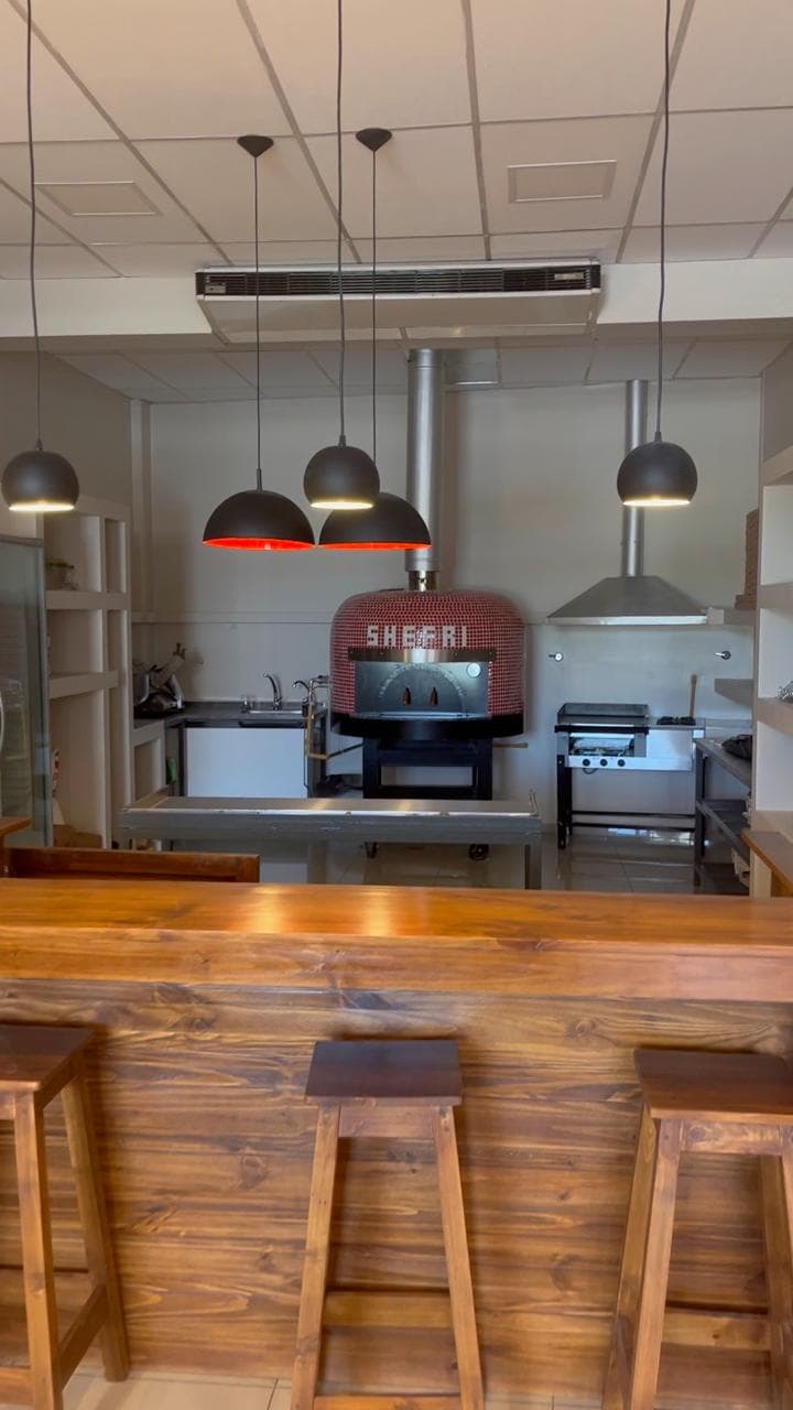 Interior del local con barra y horno napolitano